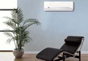 A chair in front of a wall mounted air conditioner.