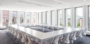 A conference room with a long table and chairs.